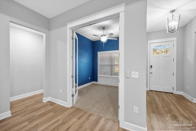 entrance foyer featuring ceiling fan with notable chandelier and light hardwood / wood-style floors