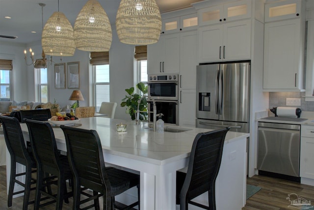 kitchen featuring stainless steel appliances, a healthy amount of sunlight, a sink, and white cabinetry