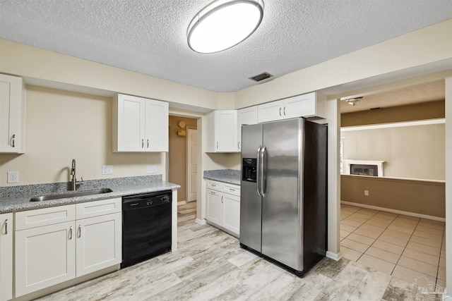 kitchen with white cabinets, dishwasher, sink, and stainless steel fridge