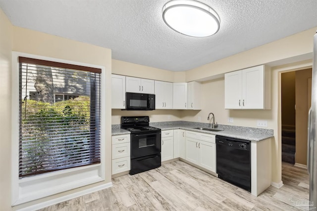 kitchen with black appliances, sink, and white cabinetry