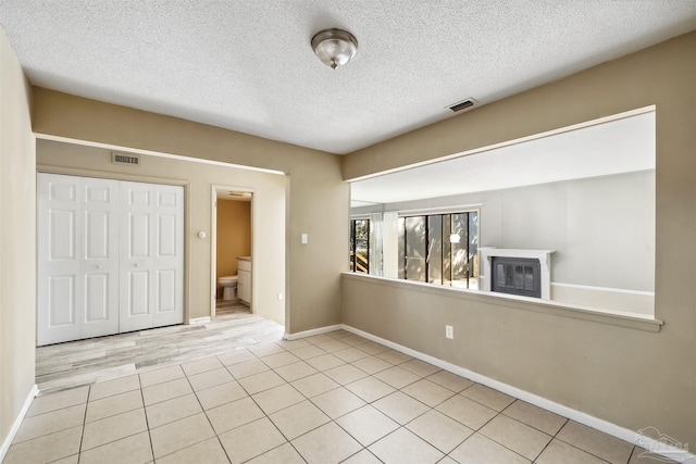 interior space featuring light tile patterned flooring and a textured ceiling