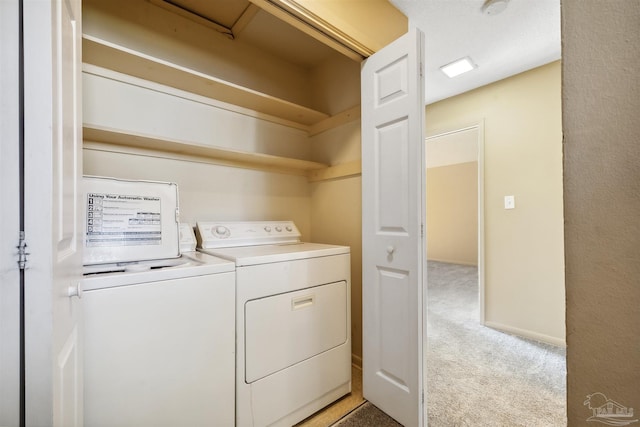 laundry room featuring light colored carpet and washer and clothes dryer