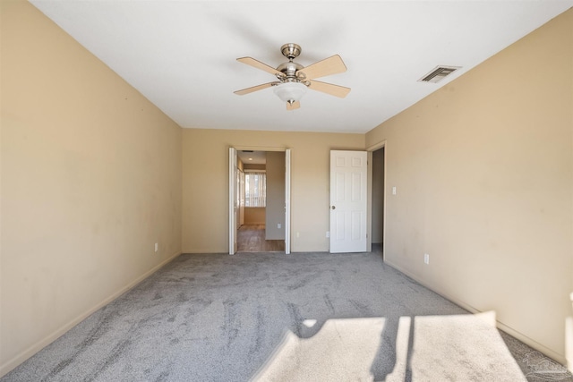 unfurnished bedroom featuring ceiling fan, ensuite bath, and light colored carpet