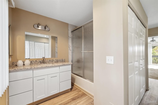 bathroom featuring combined bath / shower with glass door, vanity, and hardwood / wood-style floors