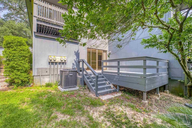 rear view of house featuring a balcony, a lawn, and central AC unit