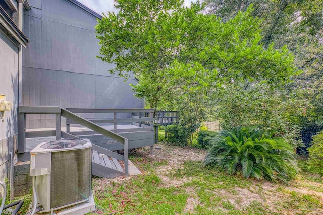 view of yard featuring cooling unit and a deck