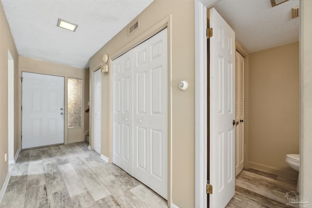 entrance foyer featuring a textured ceiling and light wood-type flooring