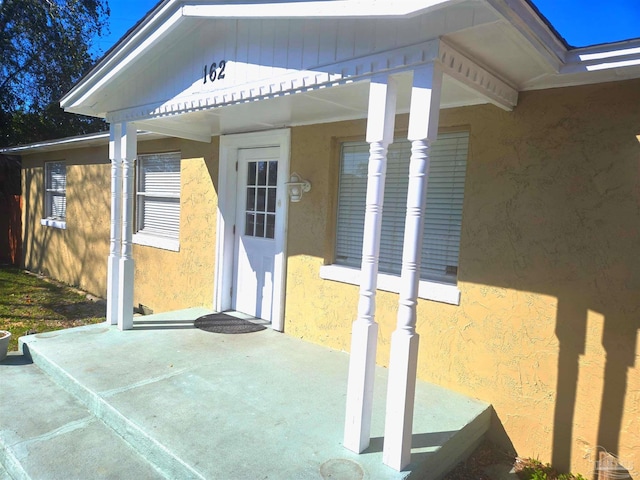 doorway to property with a patio and stucco siding