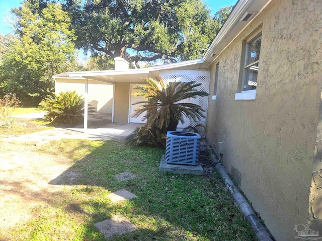 view of property exterior featuring cooling unit, a yard, and stucco siding