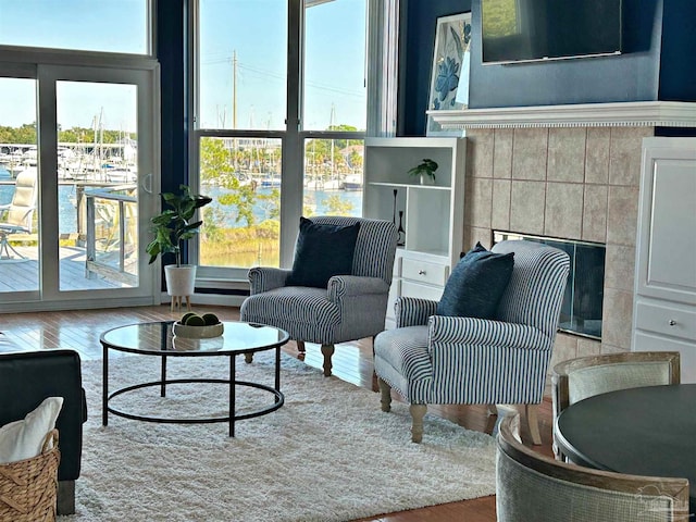 living room featuring a tiled fireplace and wood-type flooring