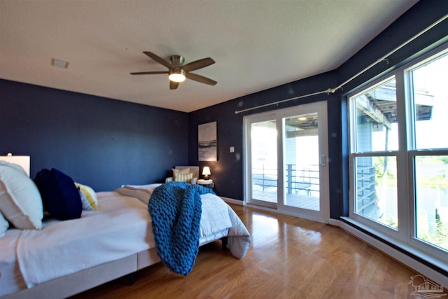 bedroom featuring a baseboard radiator, hardwood / wood-style flooring, access to outside, and ceiling fan