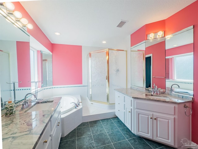 bathroom with vanity, plus walk in shower, a textured ceiling, and tile patterned flooring