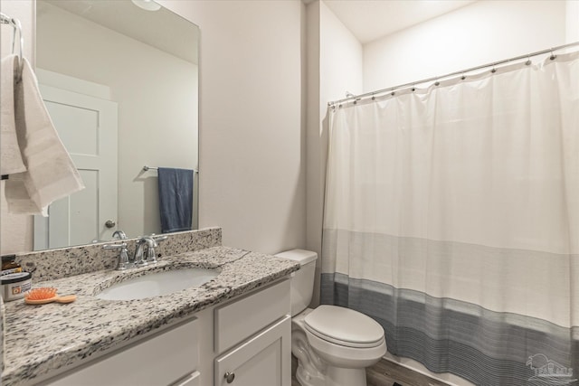 bathroom with toilet, vanity, and a shower with shower curtain