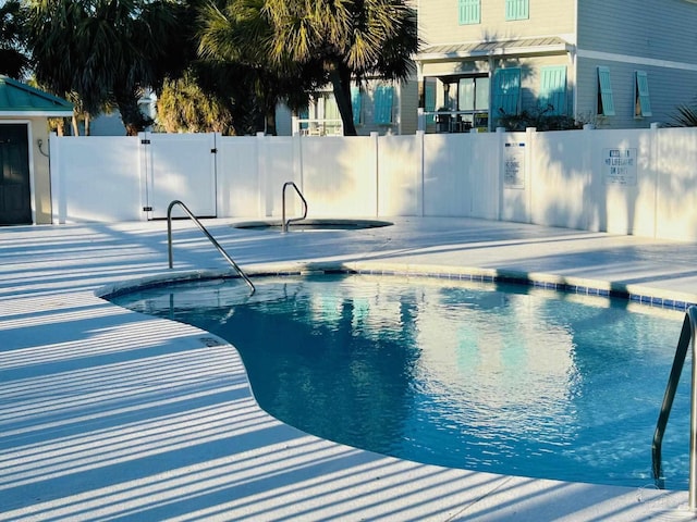 pool with a patio area and fence