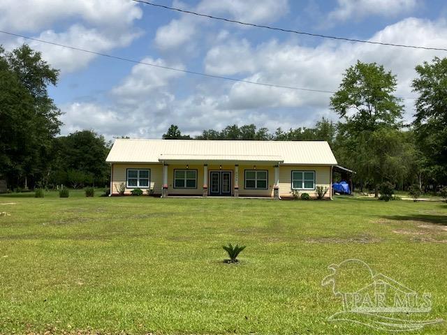 5434 Lilac Ave, Milton, FL 32570 - view of front of property with a front yard and metal roof
