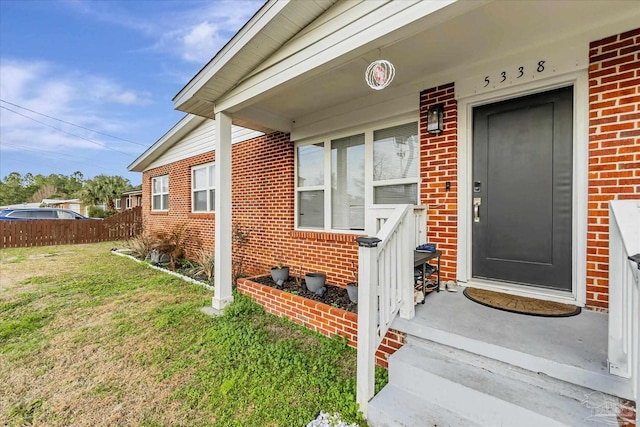 view of exterior entry with a yard