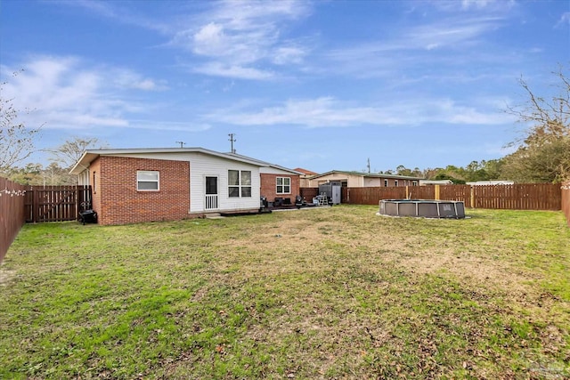 back of house featuring a fenced in pool and a lawn