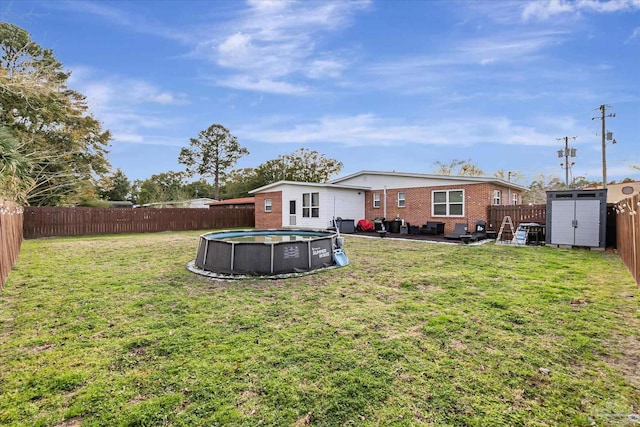 view of yard with a fenced in pool, a patio, and a storage unit