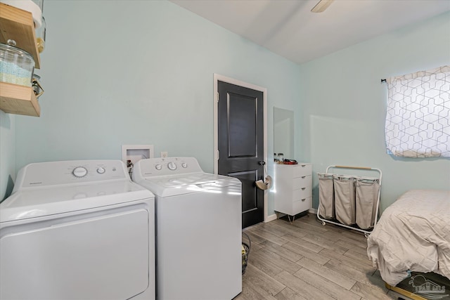 clothes washing area featuring washer and clothes dryer and light hardwood / wood-style flooring