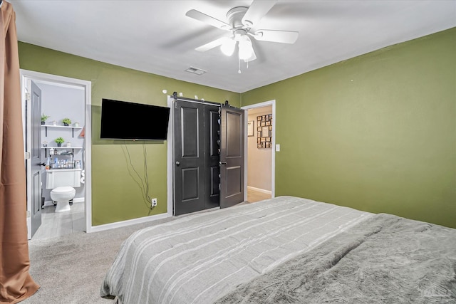 bedroom featuring ensuite bathroom, carpet, and ceiling fan