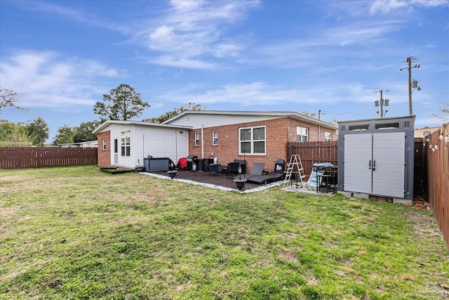 back of property with a storage shed, a patio area, and a lawn