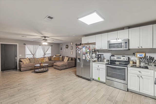 kitchen featuring white cabinetry, stainless steel appliances, and light stone countertops