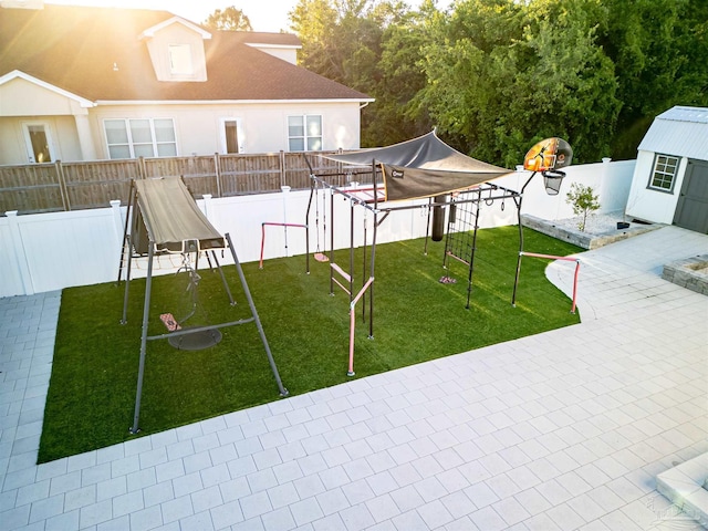 view of yard with a fenced backyard, an outdoor structure, a patio area, a playground, and a trampoline