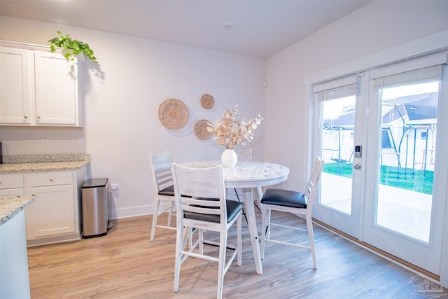 dining area featuring baseboards and light wood-type flooring