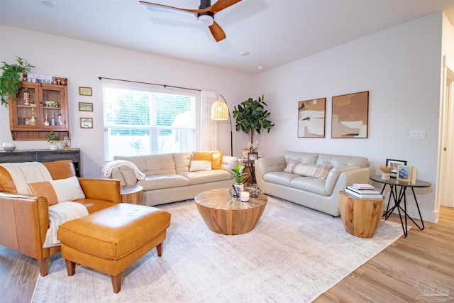 living area with light wood-style flooring and ceiling fan