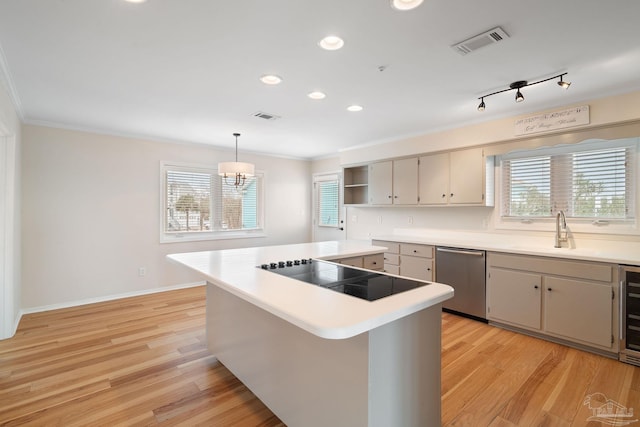 kitchen featuring sink, decorative light fixtures, light hardwood / wood-style flooring, stainless steel dishwasher, and a kitchen island