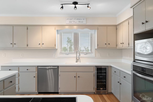 kitchen with sink, gray cabinets, stainless steel appliances, and beverage cooler