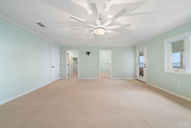 spare room featuring light carpet, crown molding, and ceiling fan