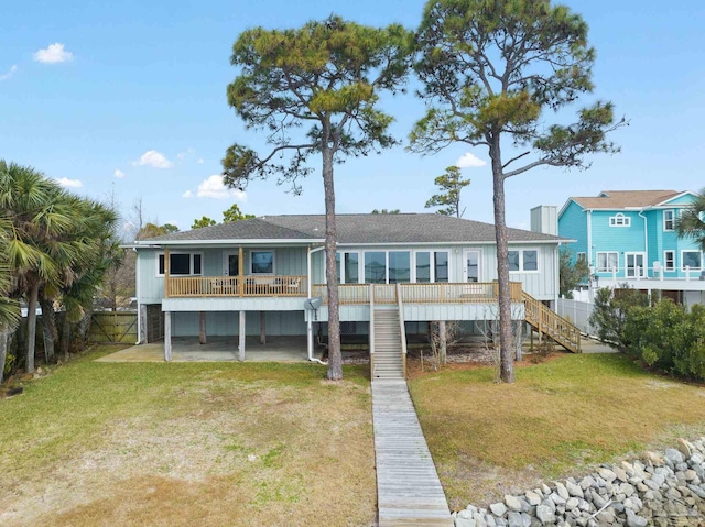 rear view of house featuring a carport and a lawn