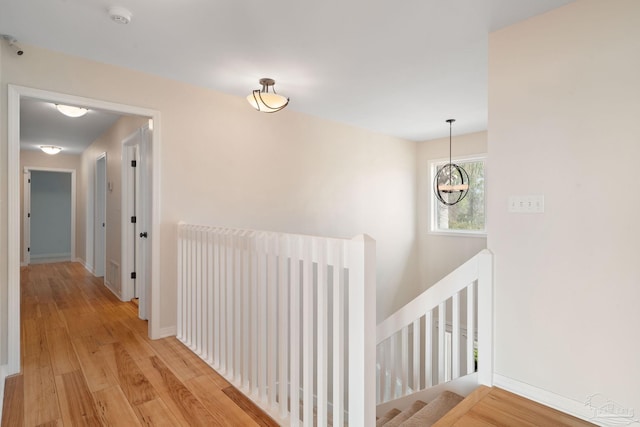 hallway with a chandelier and light hardwood / wood-style flooring