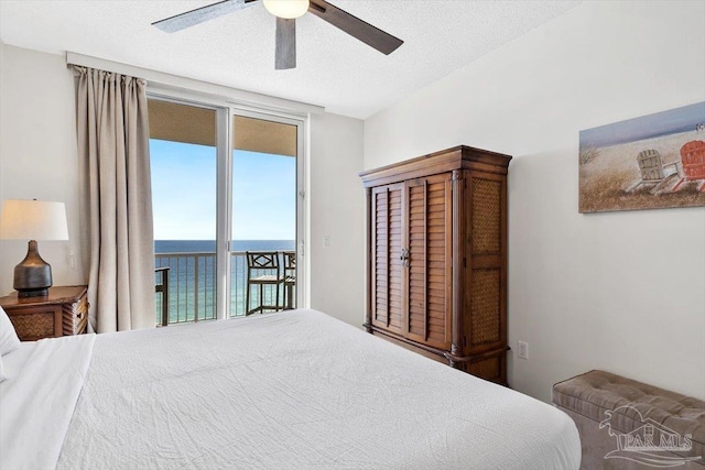 bedroom with a water view, ceiling fan, a textured ceiling, and access to outside