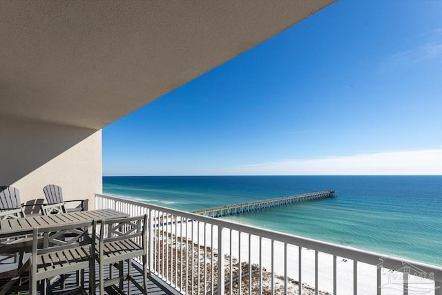 balcony featuring a view of the beach and a water view