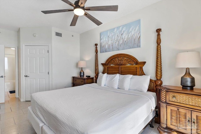 tiled bedroom with connected bathroom and ceiling fan