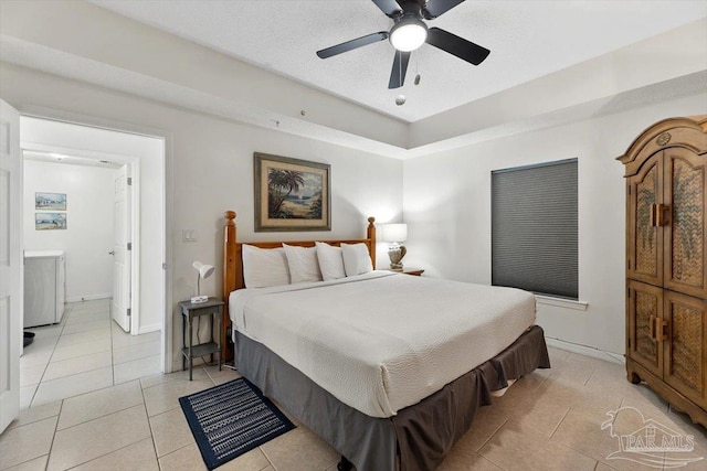 bedroom featuring washer / clothes dryer, light tile patterned floors, and ceiling fan