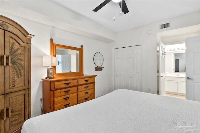 bedroom featuring ceiling fan, sink, ensuite bath, and a closet