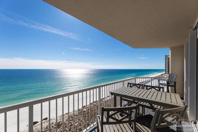 balcony with a water view and a beach view