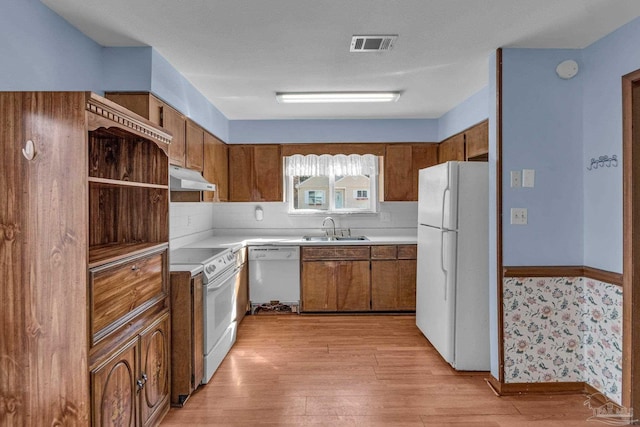 kitchen featuring sink, white appliances, tasteful backsplash, and light hardwood / wood-style flooring