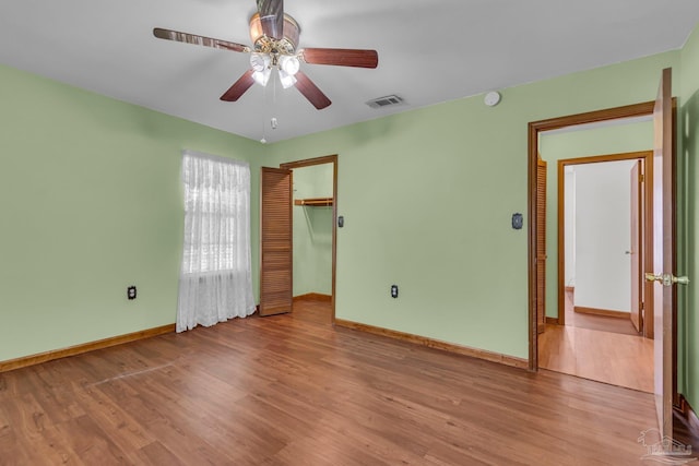 unfurnished bedroom with light hardwood / wood-style flooring, ceiling fan, and a closet