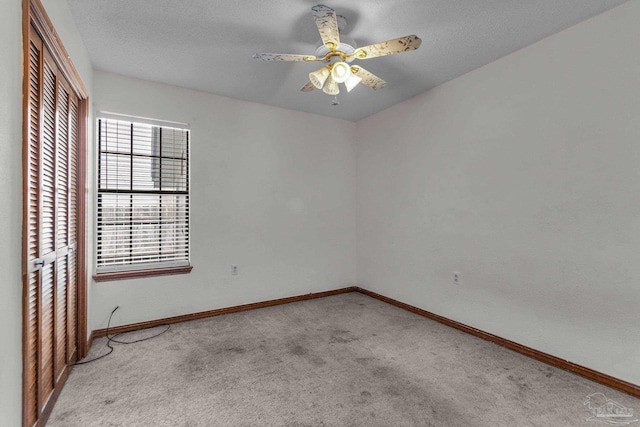 carpeted empty room with a textured ceiling and ceiling fan