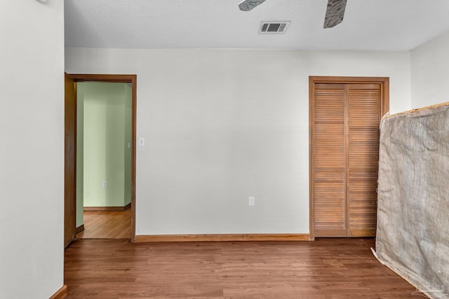 unfurnished bedroom featuring a textured ceiling, a closet, and hardwood / wood-style flooring