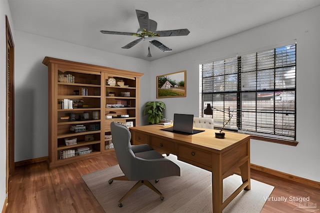 home office with ceiling fan and dark hardwood / wood-style flooring