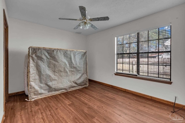 spare room with a textured ceiling, hardwood / wood-style floors, and ceiling fan