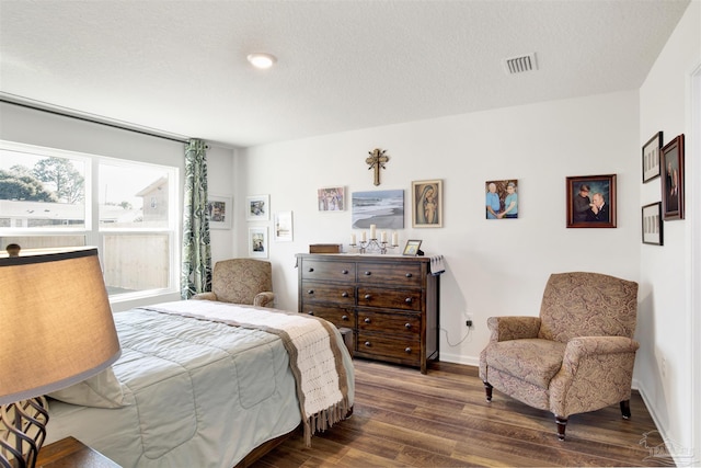 bedroom with a textured ceiling and hardwood / wood-style flooring