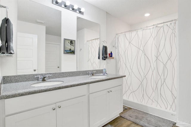 bathroom with a shower with shower curtain, hardwood / wood-style floors, and vanity