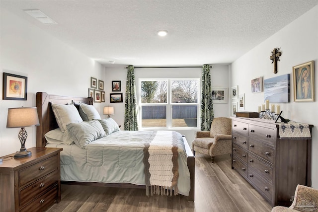 bedroom with a textured ceiling and hardwood / wood-style flooring