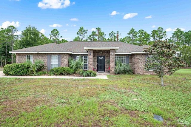 single story home featuring brick siding, roof with shingles, and a front lawn